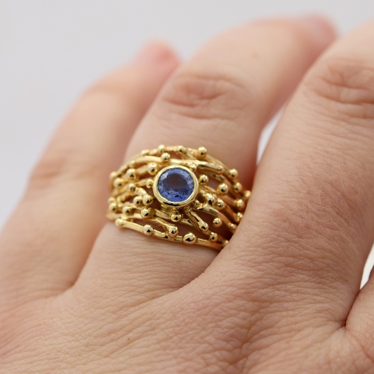 cari_brede_gouden_damesring_met_bolletjes_en_grote_blauwe_steen_in_ring_uniek_design