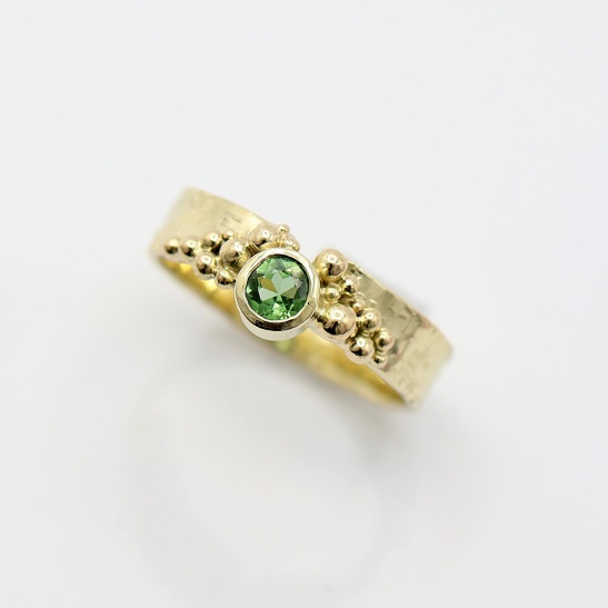 geelgouden_ring_met_bolletjes_in_verschillende_grotes_en_groene_heldere_steen