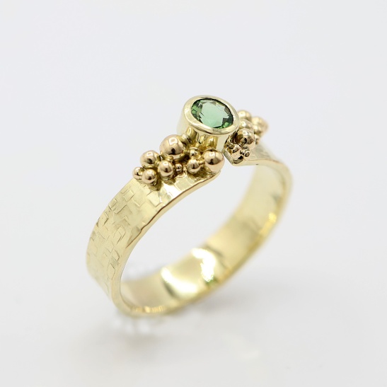 geelgouden_ring_met_groene_steen_en_bolletjes_op_ring