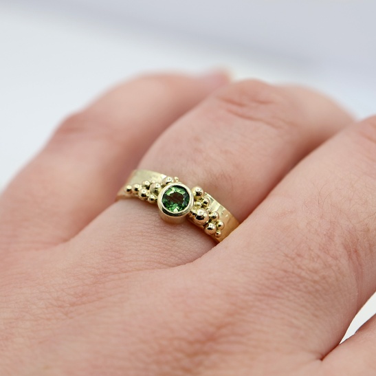 geelgouden_ring_met_hamerslag_structuur_en_gouden_bolletjes_en_groene_chroom_toermalijn