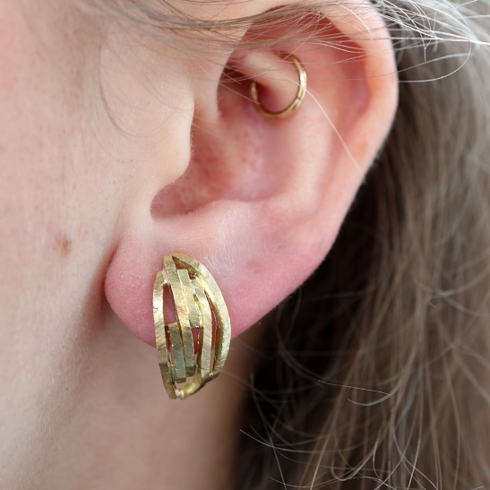 gouden_oorbellen_nerai_halfrnde_vorm_van_organische_lijnen_met_relief_structuur