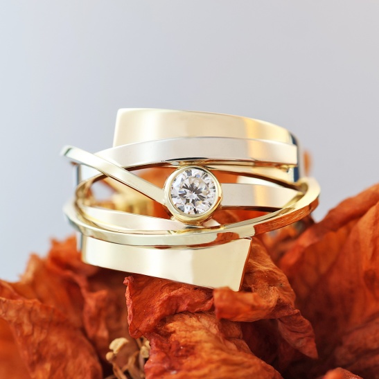 gouden ring met witgouden accenten omhelzing met diamant sfeerfoto