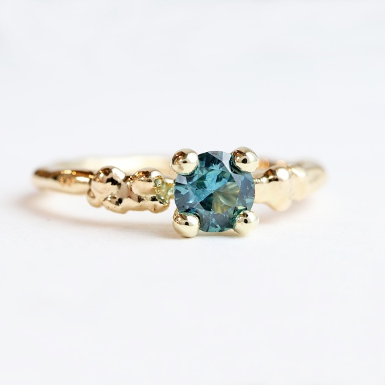 weelde_gouden_solitaire_ring_handgemaakt_met_blauwgroene_saffier_organisch_goudsmid_tessa_reijmers