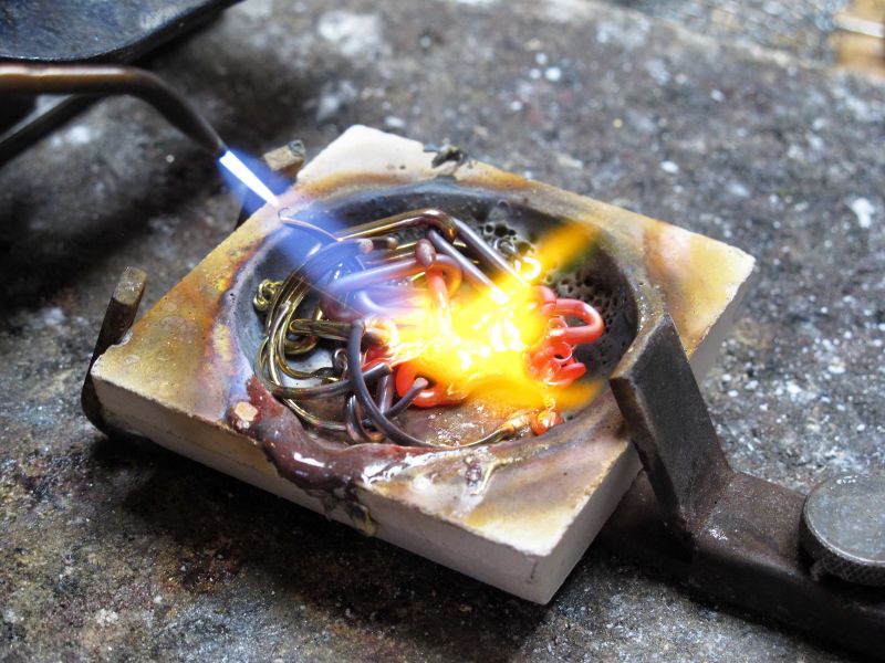 Goud wordt gesmolten in een klein bakje onder hoge temperatuur